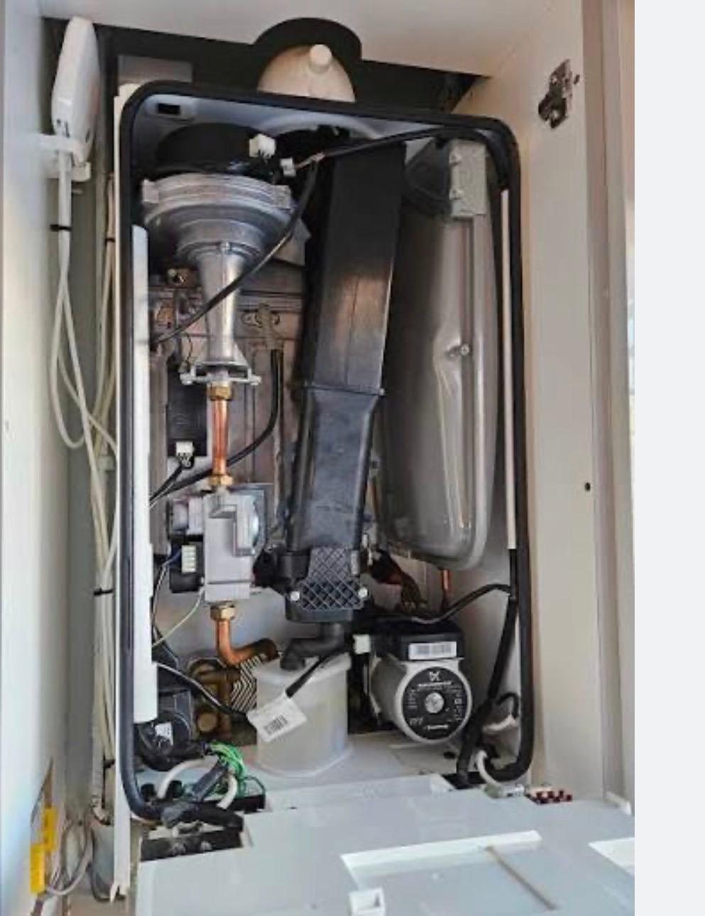 Boiler internals showing the pump and expansion vessel during a repair